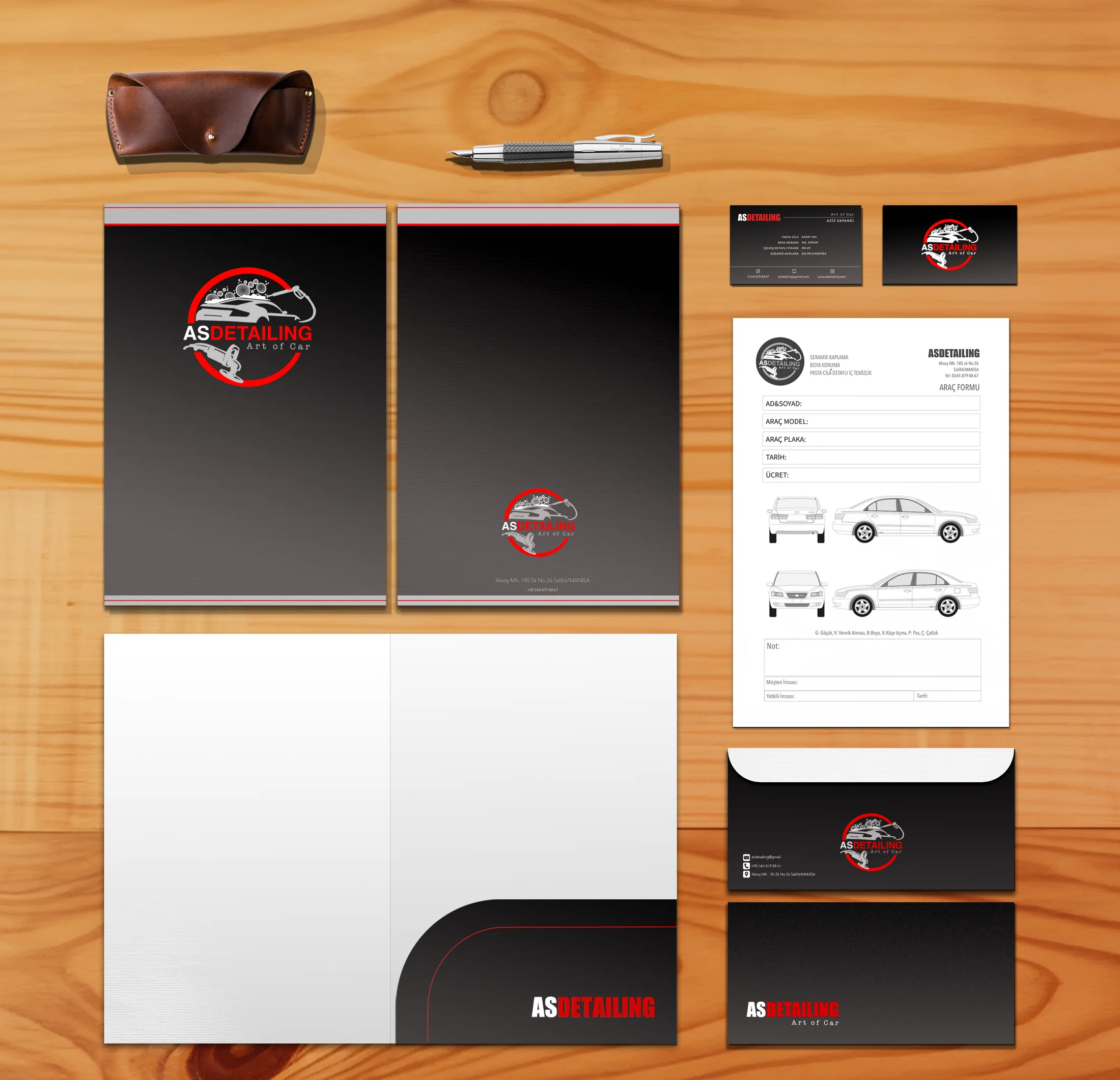 The AS Detailing corporate identity set on a wooden desk: folder covers, business cards, vehicle form, envelopes and a pocket folder