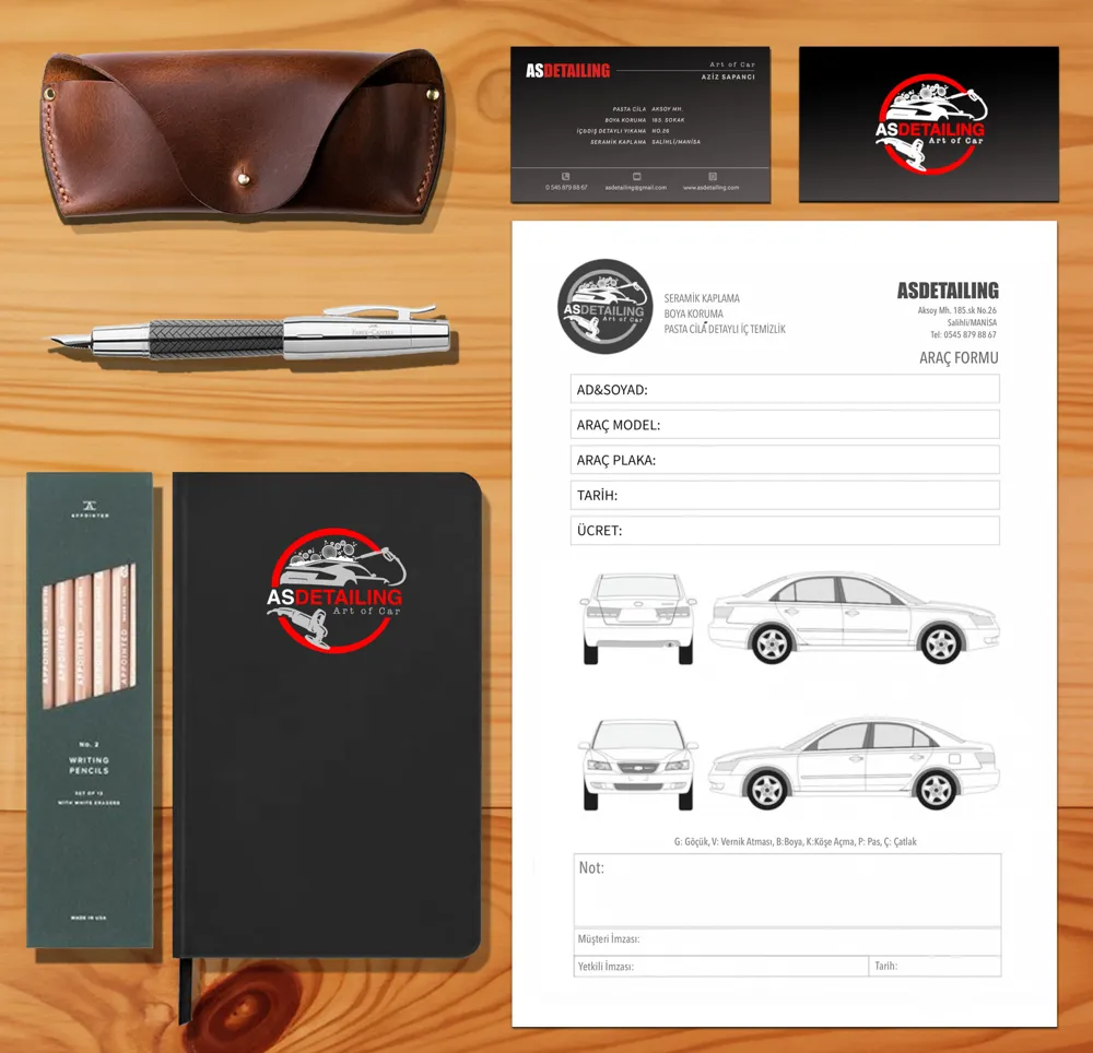 Business cards, the vehicle form, a notebook, a pen and a pen case on a wooden desk
