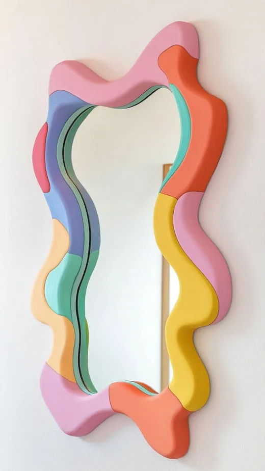 Wall mirror with a puffy frame in pink, coral, yellow and blue pieces